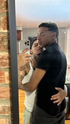 a man taking a selfie in front of a mirror while standing next to a woman