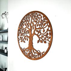 a wooden wall hanging with a tree cutout in the center and shelves on either side