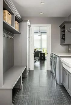 a long narrow kitchen with gray cabinets and tile flooring is seen in this image