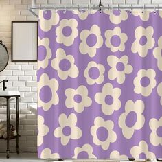 a bathroom with a purple shower curtain and white brick wall behind it that has an abstract flower pattern on it