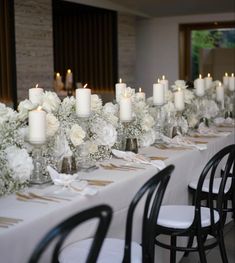 a long table with white flowers and candles