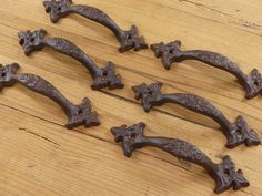 six old style iron handles on a wooden surface