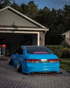 a blue car parked in front of a house with its door open and it's hood up