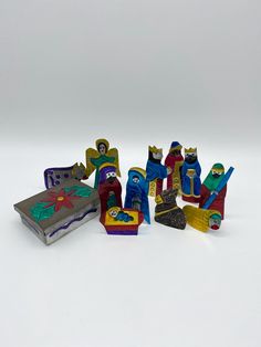 small wooden toy figurines sitting on top of a white table next to each other