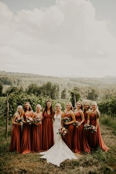 a group of women standing next to each other on top of a lush green field