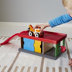 a child playing with a toy truck on the floor