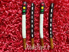 two black and white toothbrushes sitting on top of red shredded paper with green eyes