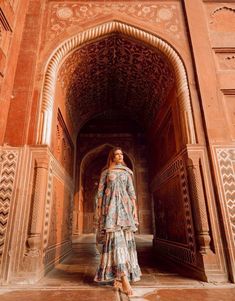 a woman is standing in the middle of an archway