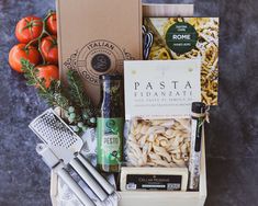 an assortment of pasta and cheeses in a wooden box next to other food items