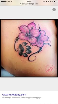 the back of a woman's stomach with pink flowers and leaves on her side