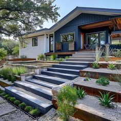 a house with steps leading up to the front door and landscaping on either side of it