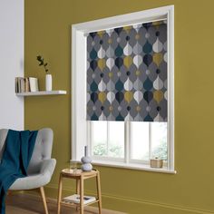 a living room with yellow walls and a grey patterned roller shade on the window sill