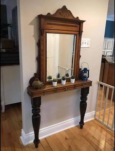 a mirror sitting on top of a wooden table with potted plants in front of it