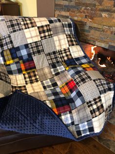 a patchwork couch sitting in front of a fire place with a blanket on it