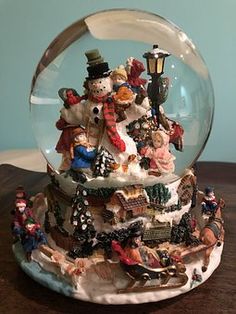 a snow globe filled with lots of different types of figurines on top of a wooden table