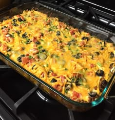 a casserole dish sitting on top of an oven with lots of toppings