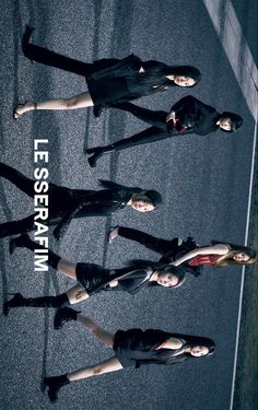 four young women in black outfits standing on the street with their arms around each other