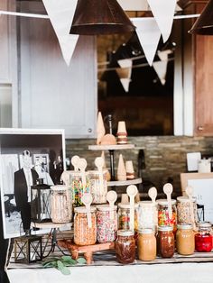 many jars and spoons are sitting on a table