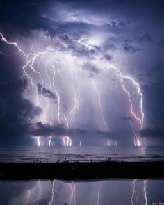 a large group of lightning strikes over the ocean