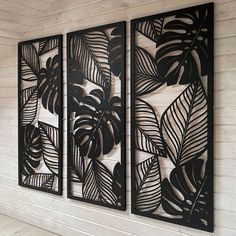 three metal wall art panels with leaves on them