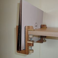 a wooden shelf with a computer monitor on it's side and some screws attached to the wall