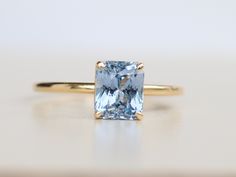 a blue diamond ring sitting on top of a table