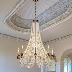 a chandelier hanging from the ceiling in a room with white walls and ceilings