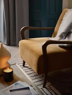 a living room scene with focus on the chair and candles in front of the window