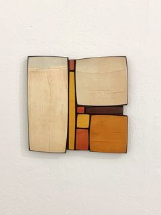 a piece of art made out of wood and paint on the side of a wall