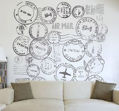 a white couch sitting in front of a wall with stamps on it