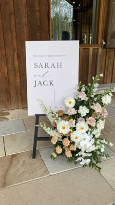 a bouquet of flowers sitting in front of a sign that reads,'welcome to the wedding of sarah and jack '