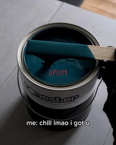 a person holding a paint brush in their hand and painting the inside of a can