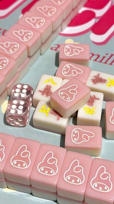 pink and white dices with faces on them sitting next to each other in front of a game board