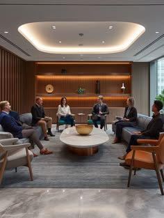 several people sitting in chairs around a coffee table