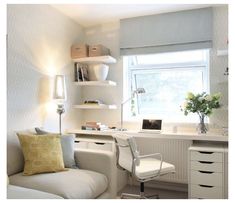 a living room with a couch, desk and shelves on the wall next to it