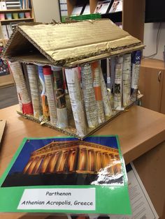 there is a small house made out of books on top of a table in the library