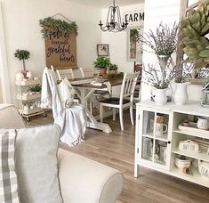 a living room filled with furniture and lots of plants on top of it's shelves