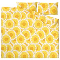 yellow and white bedding with large flowers on the bottom, along with matching pillow cases