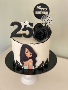 a white and black birthday cake with a woman's face on the top tier