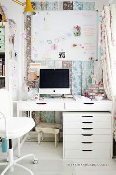 a white desk with a computer on top of it next to a chair and window