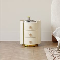 a white nightstand sitting on top of a hard wood floor