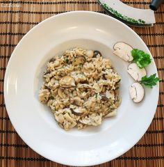 a white plate topped with pasta and mushrooms