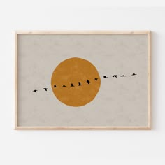 birds are flying in front of the sun on a gray and orange background, framed art print