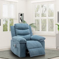 a blue recliner chair sitting in a living room next to a potted plant