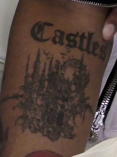 a man with a tattoo on his arm that reads castle and has a clock in it