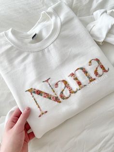 someone is stitching the letters on a t - shirt that says,'mom '