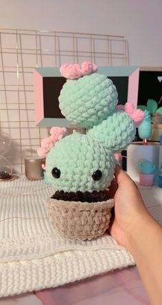 someone is holding up a crocheted cupcake