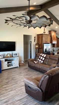 a living room filled with furniture and a flat screen tv on top of a wooden ceiling