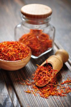 a wooden spoon and glass jar filled with dried saffroni