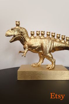 a gold colored dinosaur figurine with candles in it's mouth